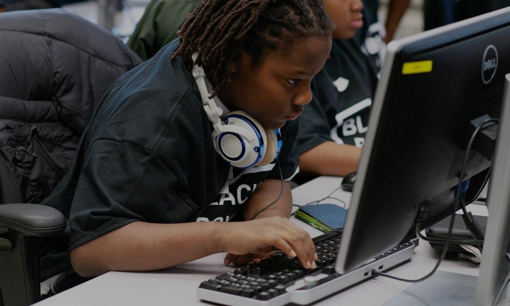 Black youths looking at computer screen